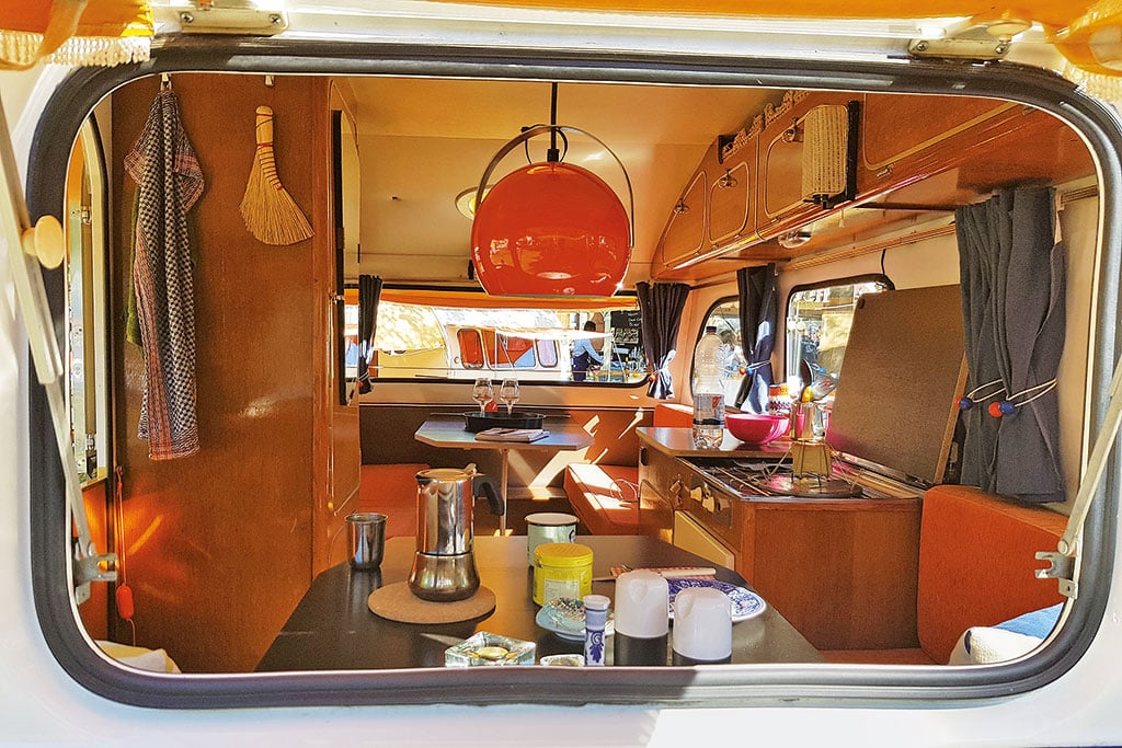 Blick durchs Fenster ins Innere eine Wohnwagens aus den 70er Jahren