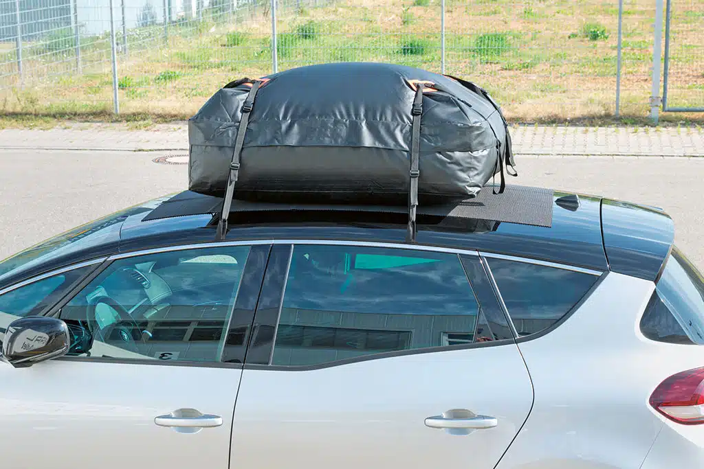 Schwarze Dachtasche befestigt auf einem Autodach