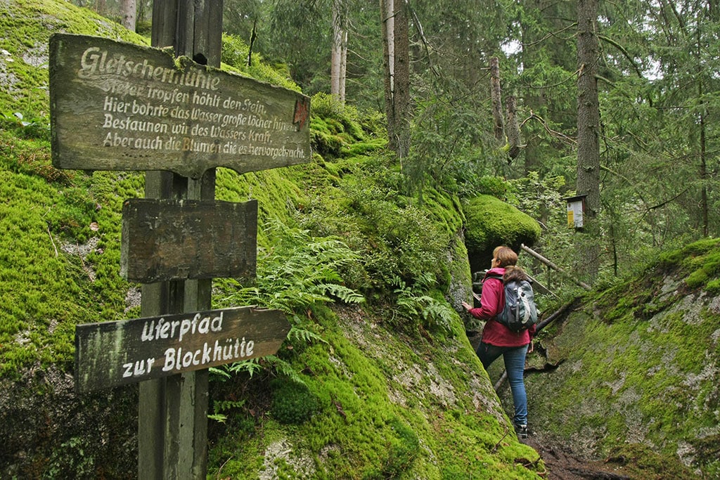 Wanderin zwischen moosbedeckten Felsen im Wald