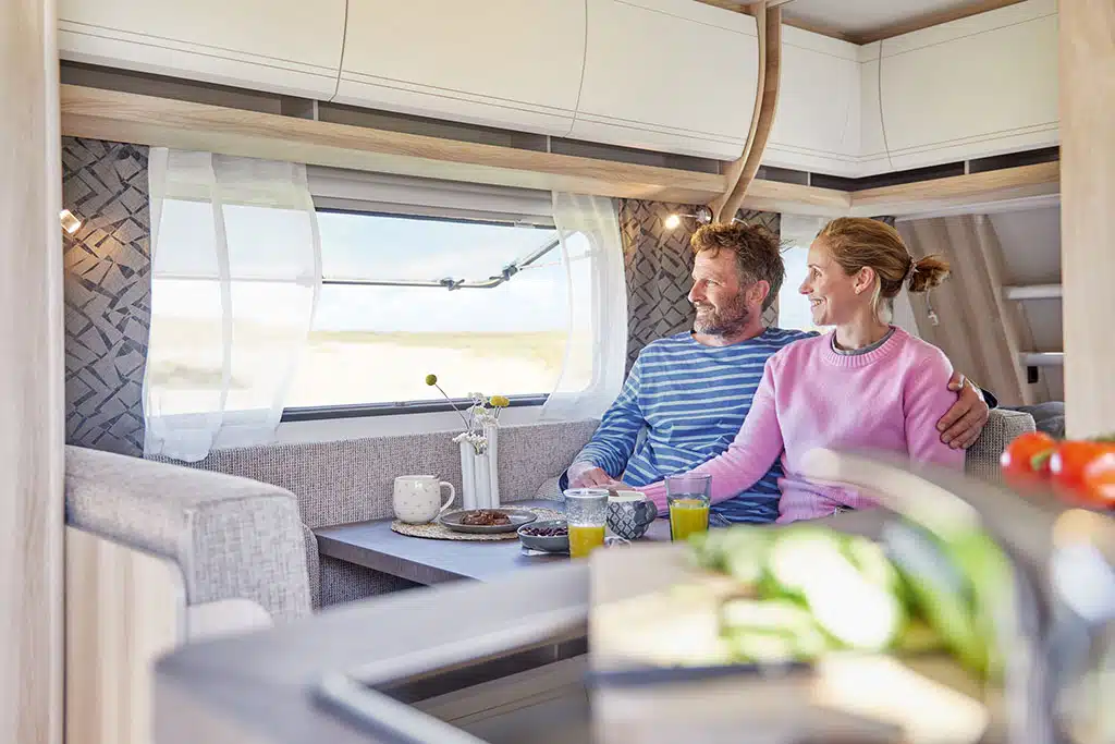 Frau und Mann sitzen im Wohnwagen Hobby De Luxe