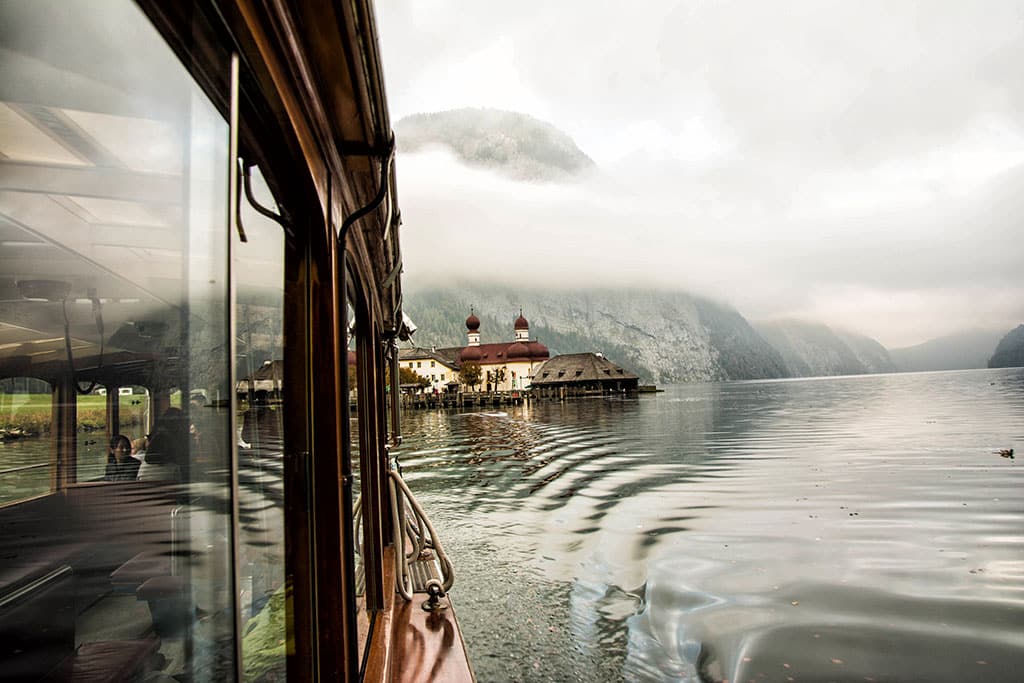 Wallfahrtskirche St. Martholomä am Königssee, dahinter nebelverhangene Berge