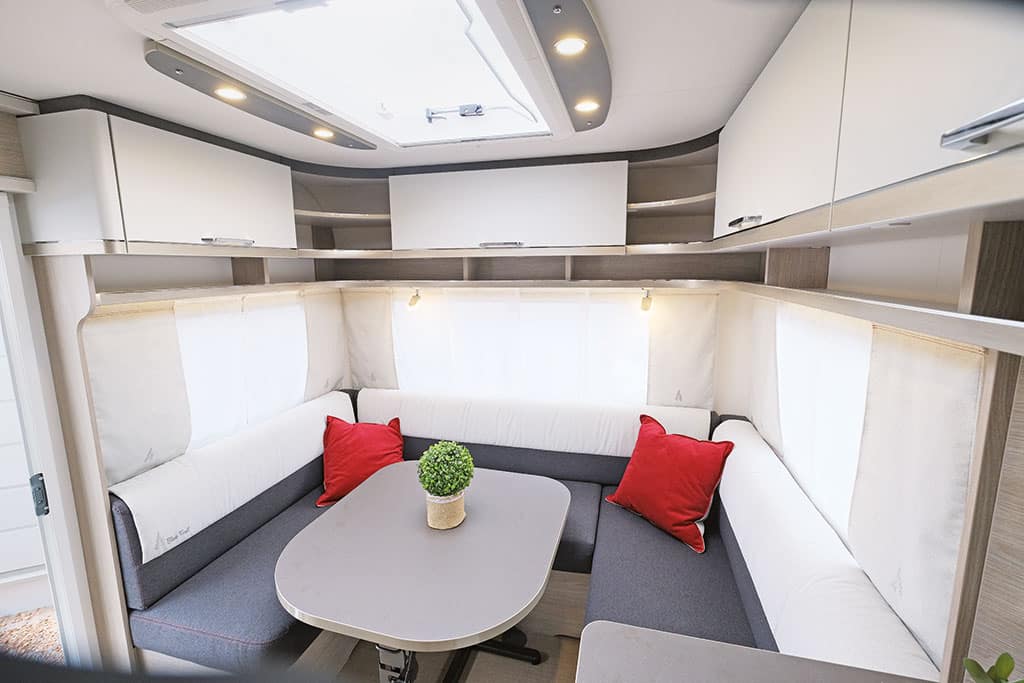 Sitzgruppe im Bürstner Premio Black Forest mit grauer Polsterung und über der Sitzgruppe befindlichem großen Dachfenster