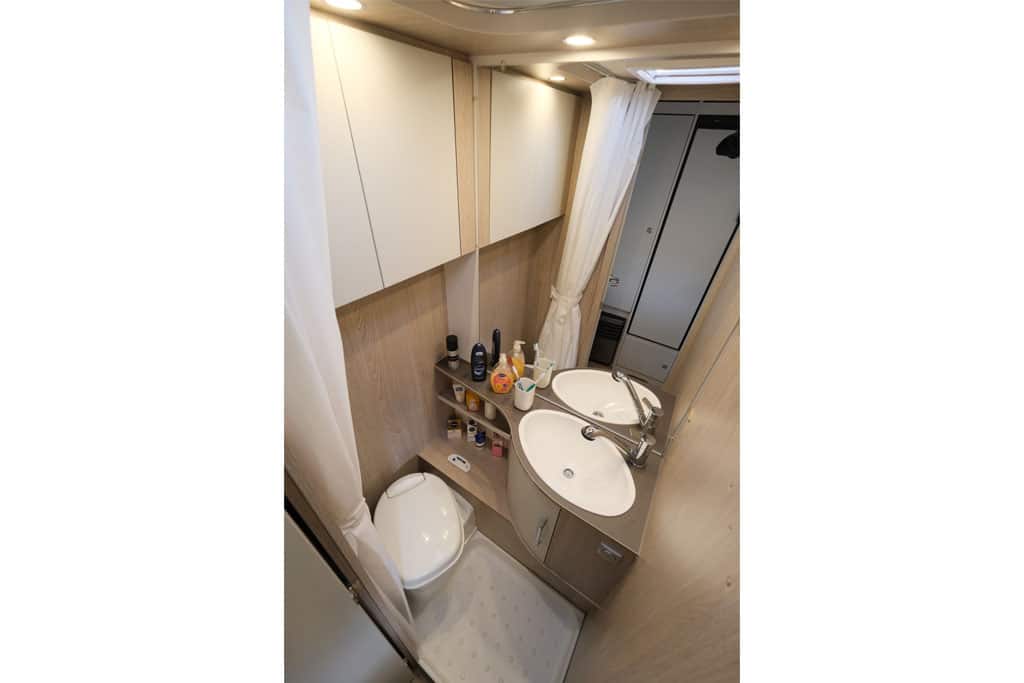 Kleines Bad mit ovalem Waschbecken, Toilette und Duschwanne im Wohnwagen