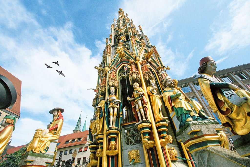Kunstvoll gestalteter Brunnen mit bunten Figuren