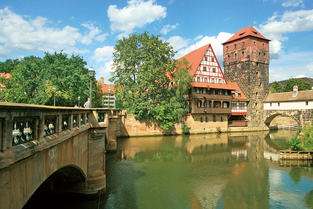 Steinerne Brücke über einen Fluß, im Hintergrund ein Fachwerkhause