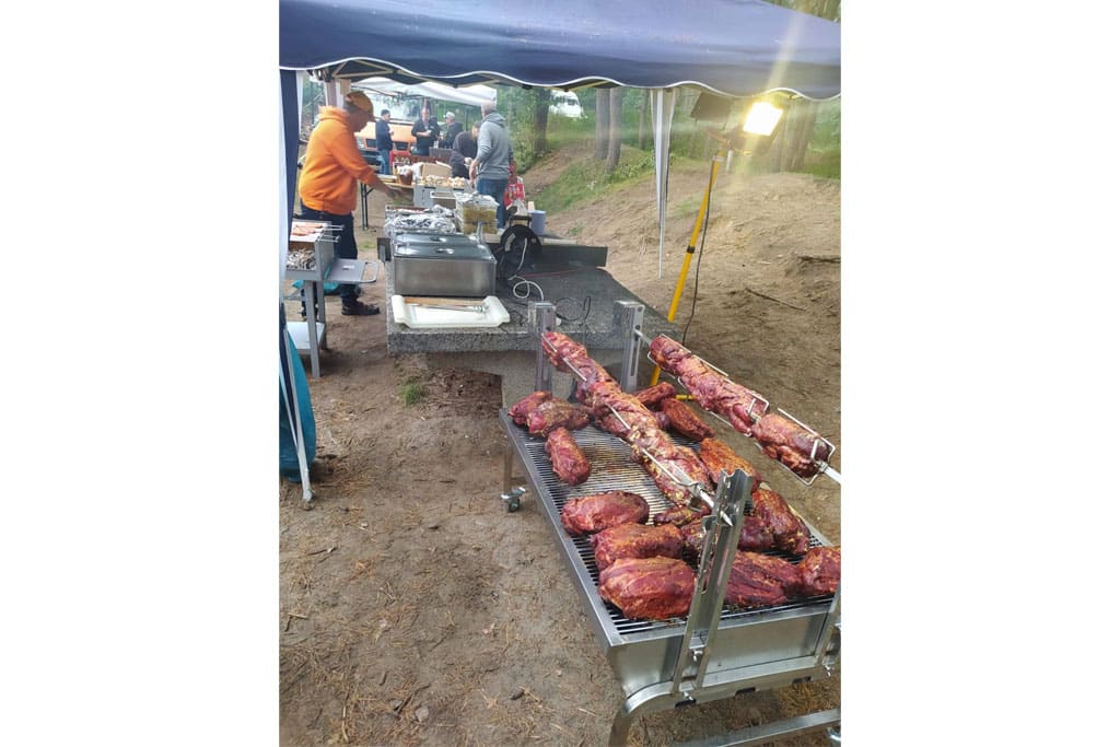 Mann grillt eine große Menge Fleisch