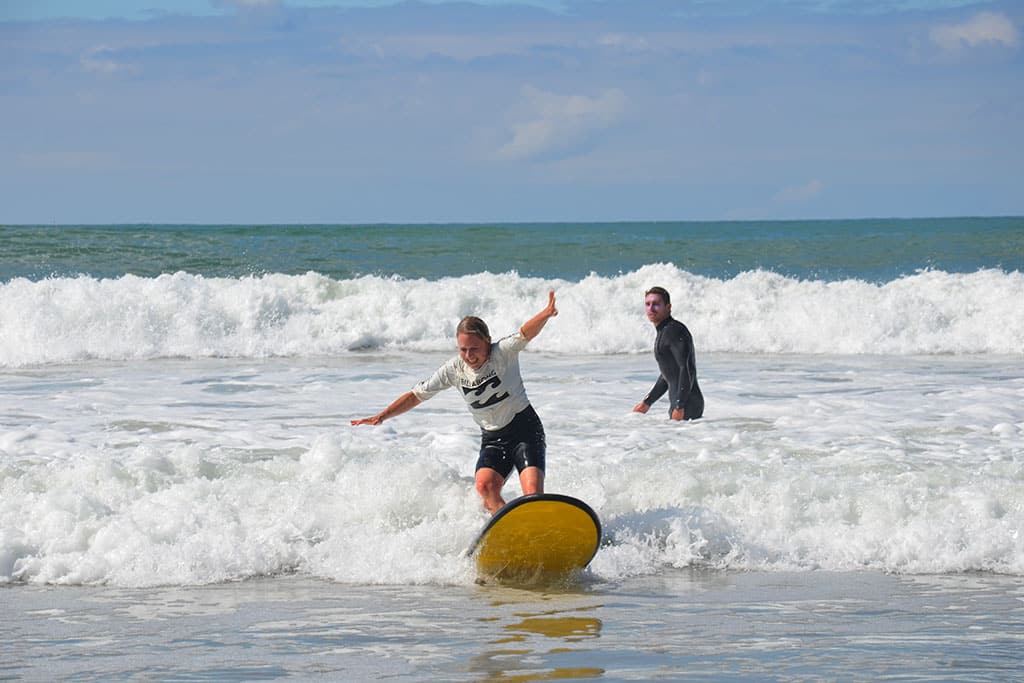 Surferin und Surflehrer beim Surfkurs