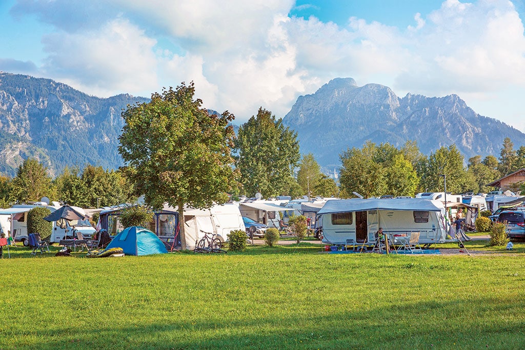 Caravans auf einer Wiese vor Alpenkulisse