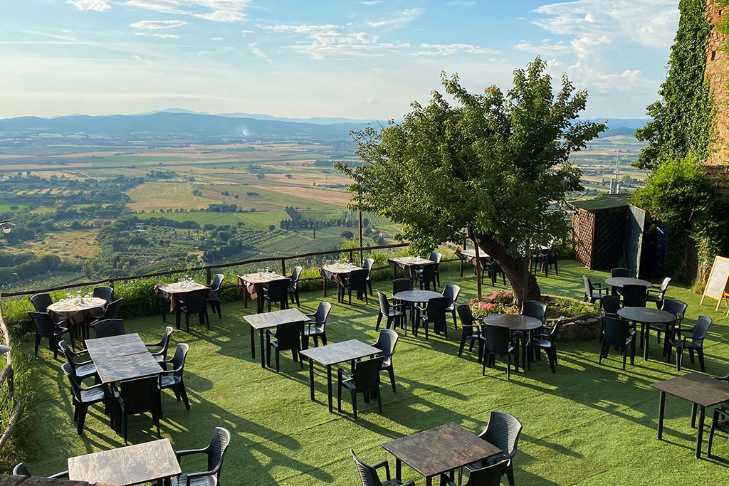 Restaurant-Außensitzplätze auf Kunstrasen mit Blick auf eine weite Hügellandschaft