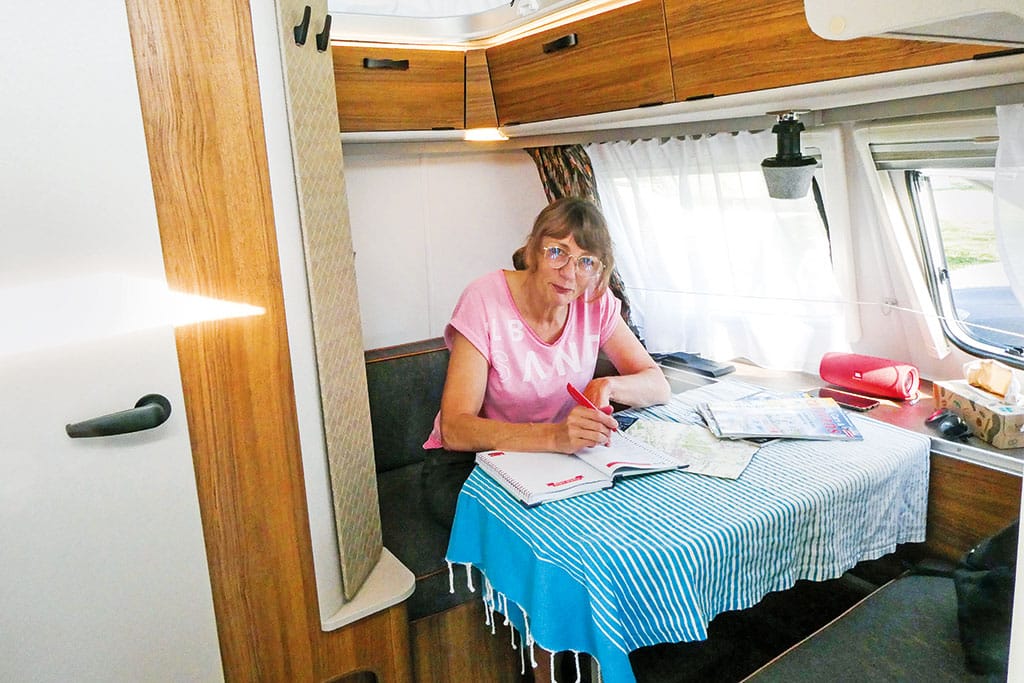 Camperin in der Sitzecke des Eriba Touring Wohnwagens