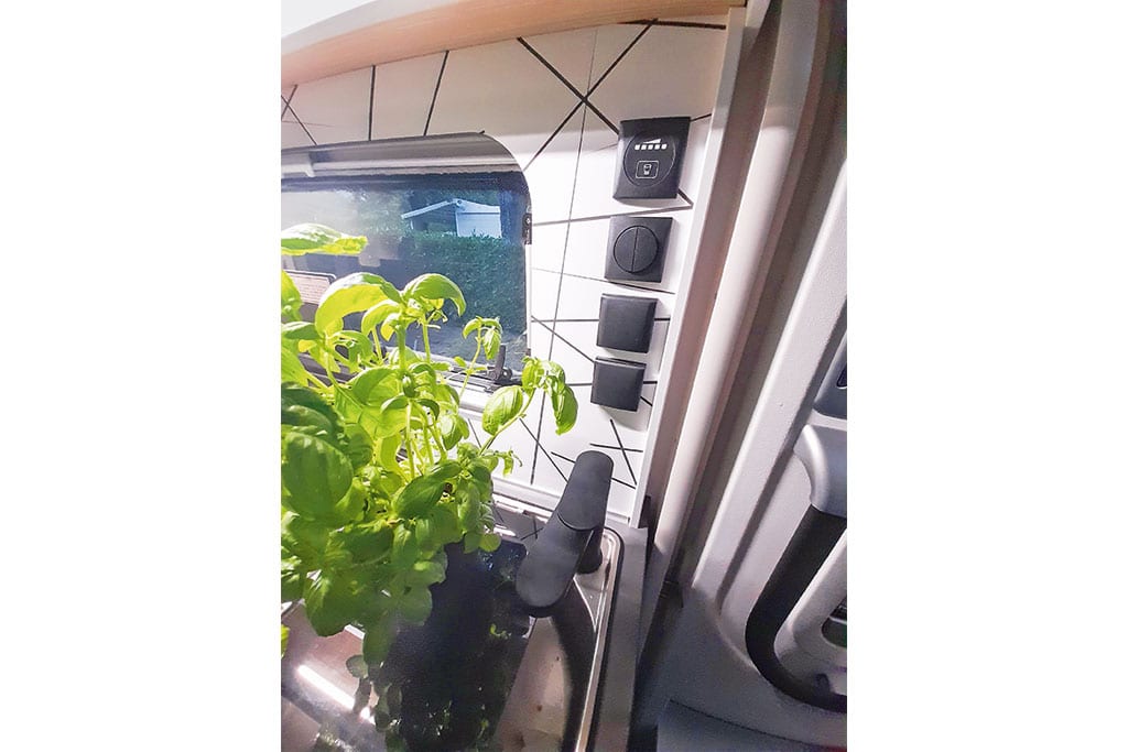 Diverse Steckdosen und Schalter an Küchenrückwand im Wohnwagen