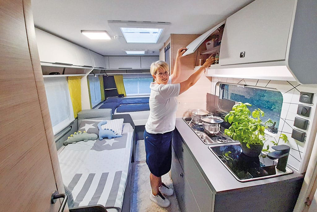Frau steht im Innenbereich des Wohnwagens