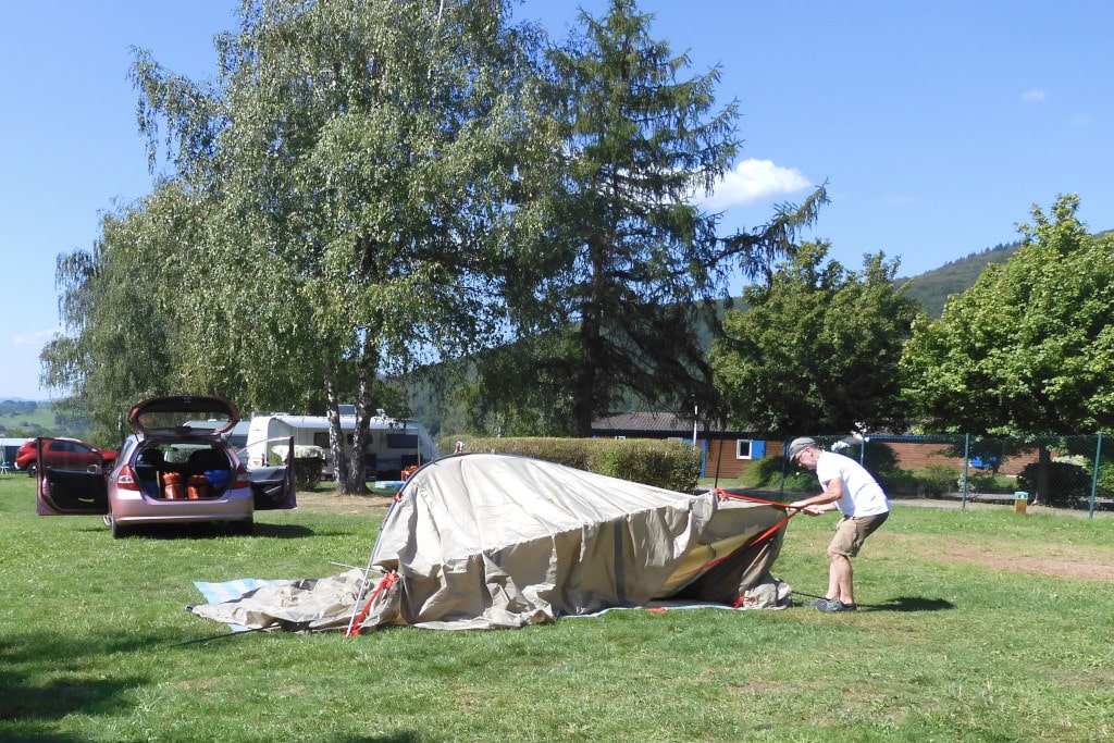Die Stangen des Zeltes werden an den Fixierpunkten gespannt, wodurch die Kuppel sich zu erheben beginnt.