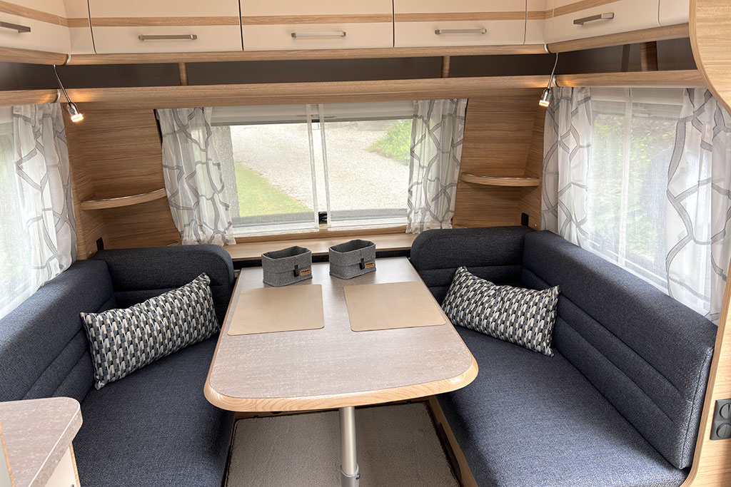 SItzgruppe im Wohnwagen aus zwei gegenüberliegenden Sitzbänken mit grauer Polsterung
