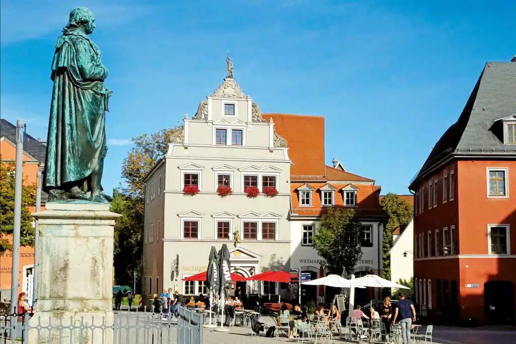 Eine Statue auf einem großen, von alten Gebäuden flankerten Platz