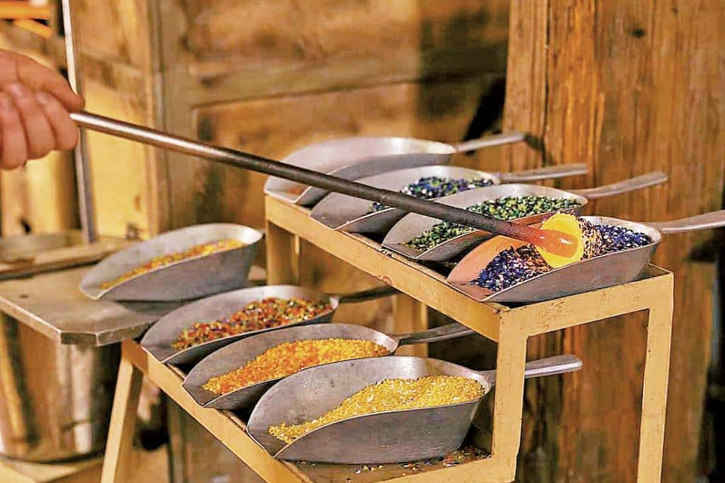 Acht Metallschaufeln mit verschiedenfarbigen Glassteinen