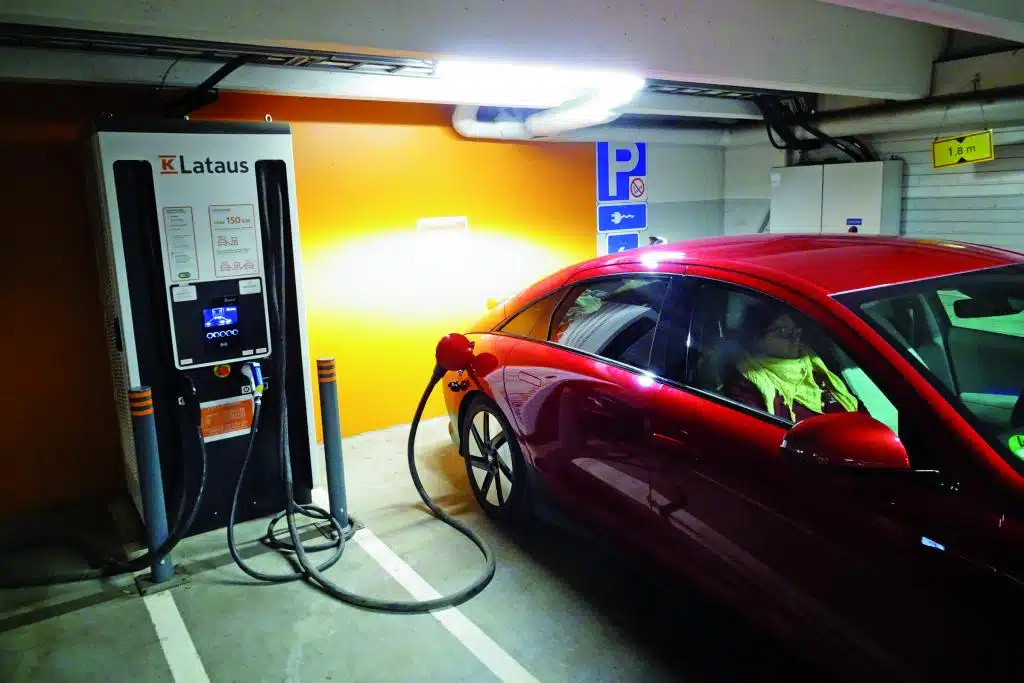 Rotes Auto an einer Strom-Ladesäule in einer Tiefgarage