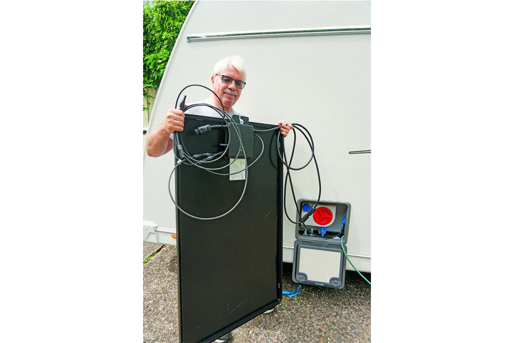 Mann hält ein Solarpanel in der Luft