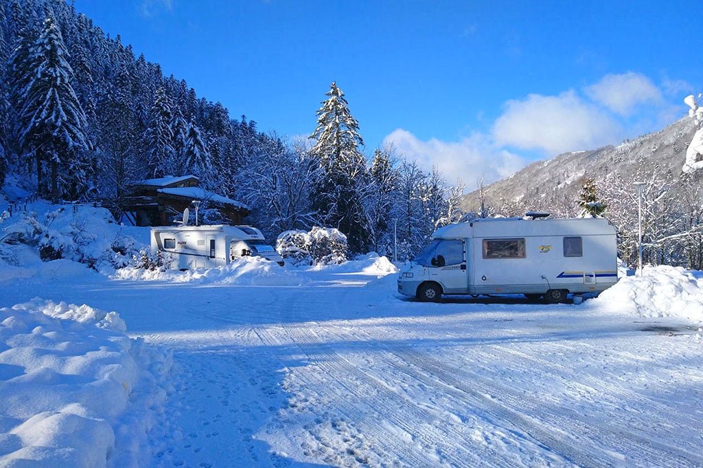 Einige Campingfahrzeuge auf einem verschneiten Campingplatz