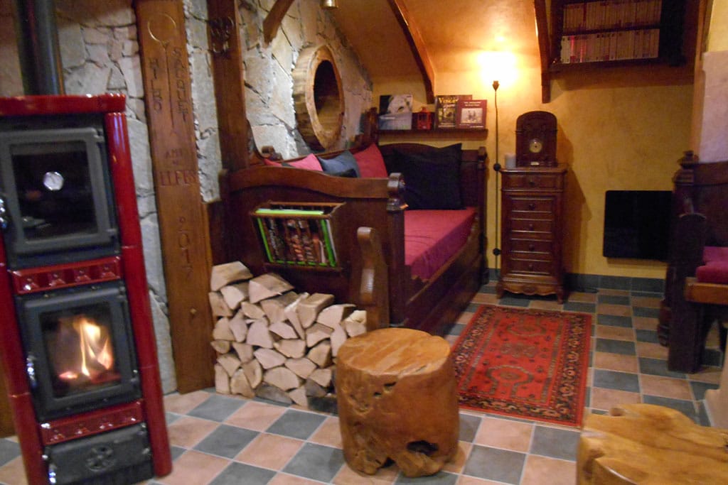 Gemütlich-uriger Wohnraum mit Holzwänden und einem Kamin