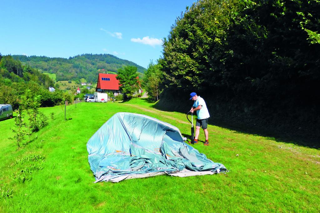 Mann beim Zeltaufbau