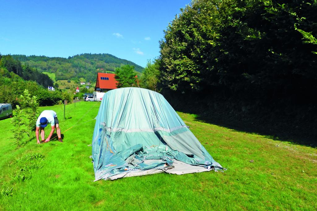 Mann beim Zeltaufbau