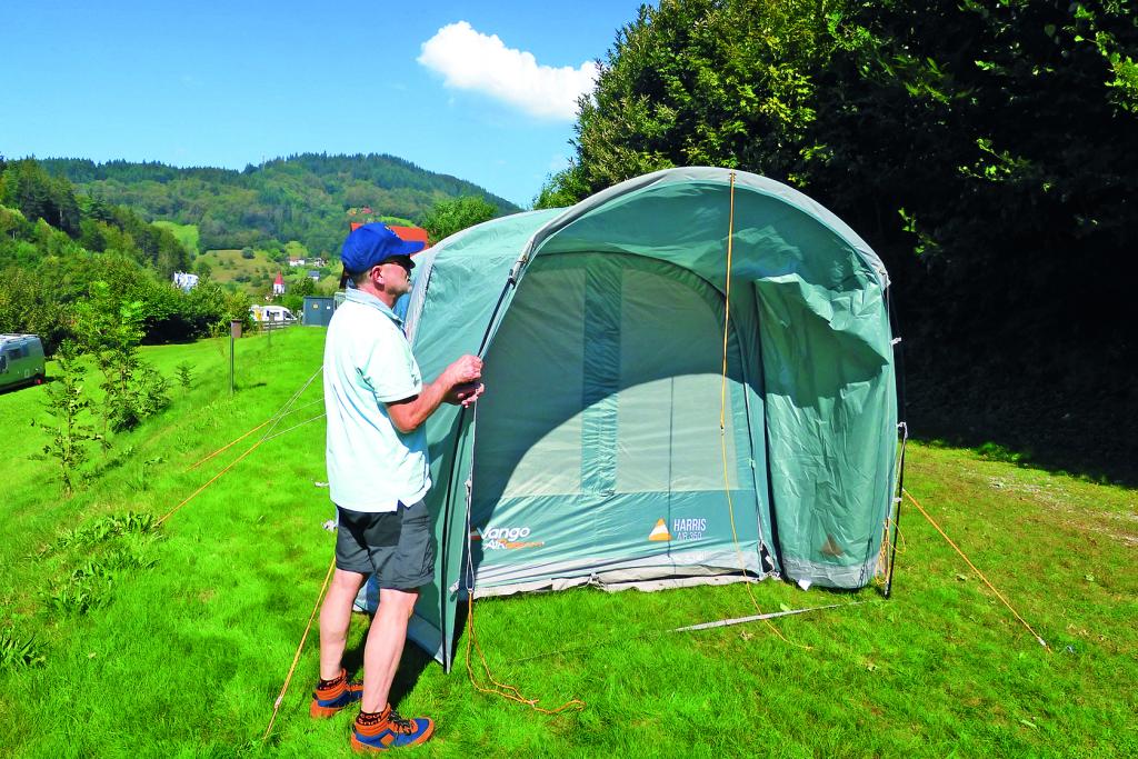 Mann beim zeltaufbau