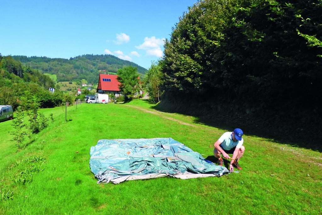 Mann beim Zeltaufbau