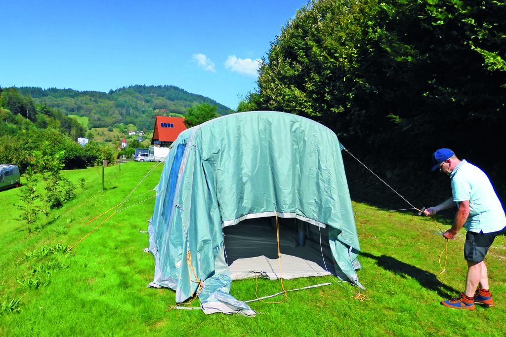 Mann beim Zeltaufbau