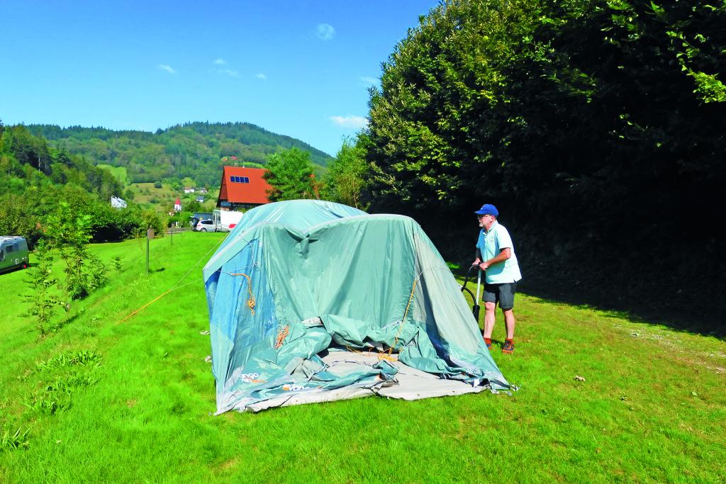 Mann beim Zeltaufbau
