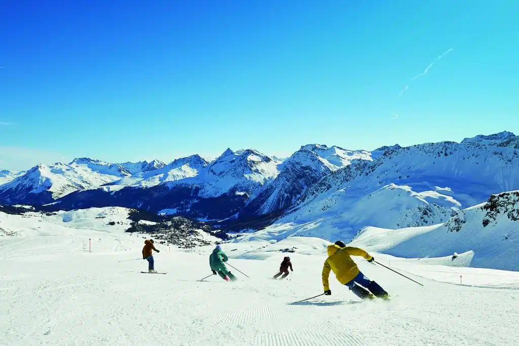 Vier Skifahrer unterwegs in verschneiter Berglandschaft