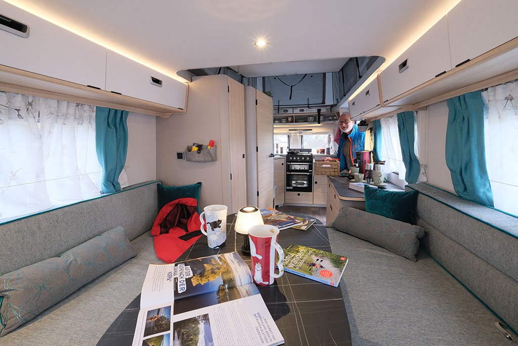 Innenansicht des Eriba Touring 620. Mit Sitzgruppe und Tisch im Vordergrund.