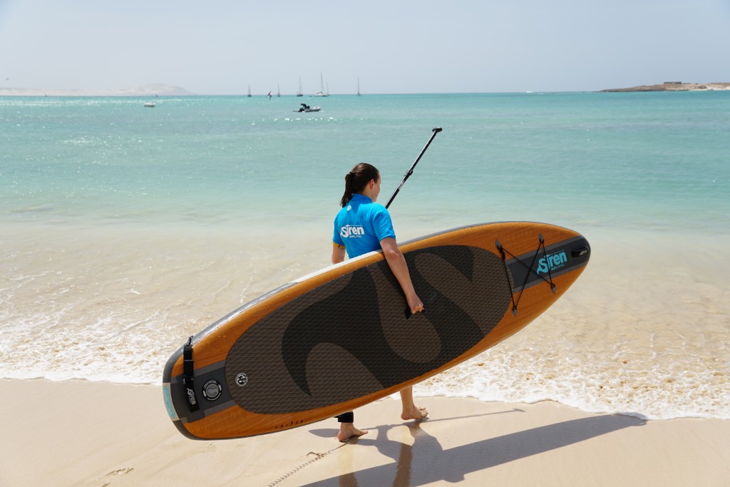 Person am Strand mit einem SUP