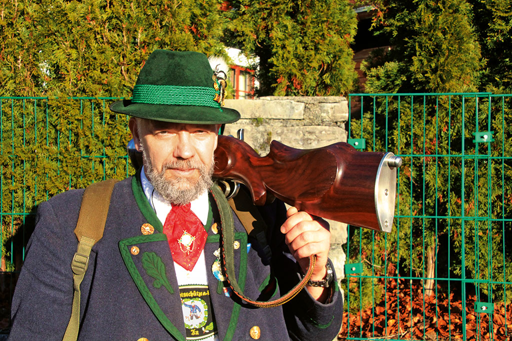 Mann mit traditioneller Tracht und Gewehr auf der Schulter